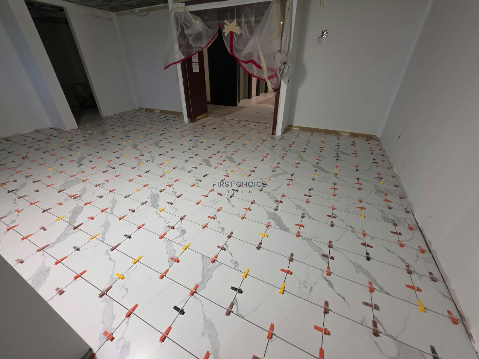 12x24 porcelain tile installation with leveling clips before grouting.