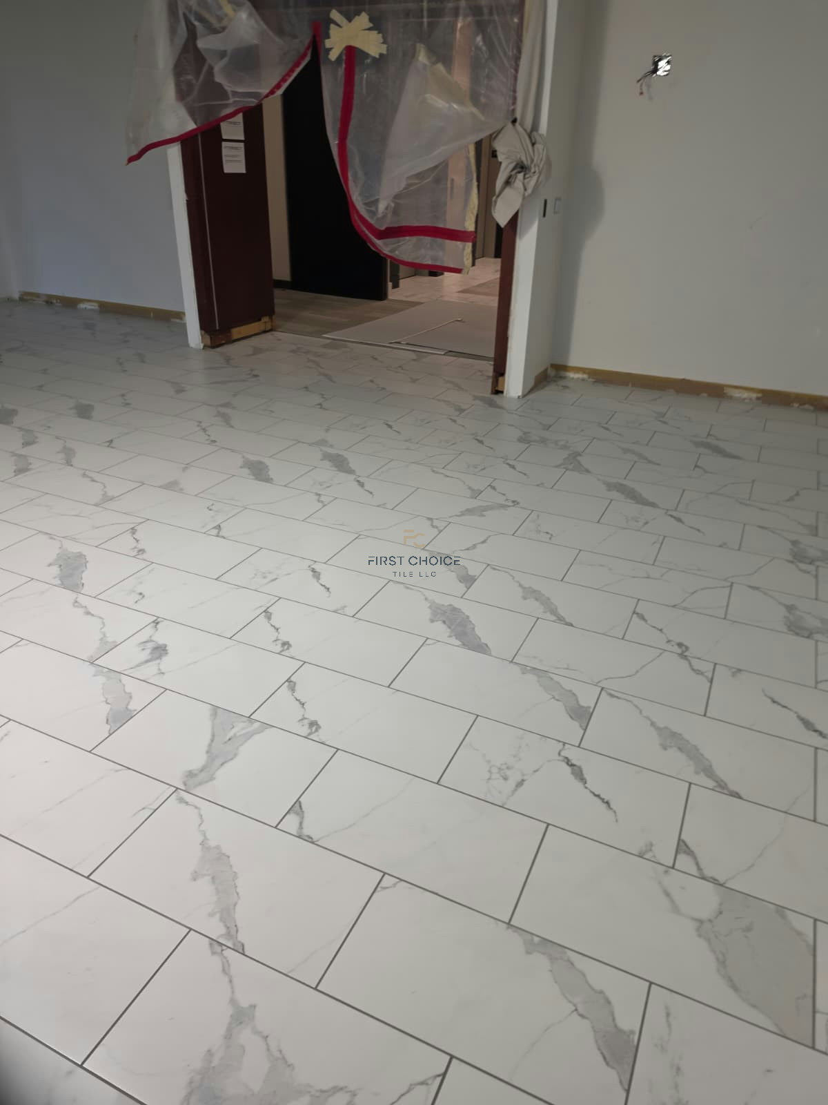 Finished marble-look porcelain tile floor with clean, even grout lines.